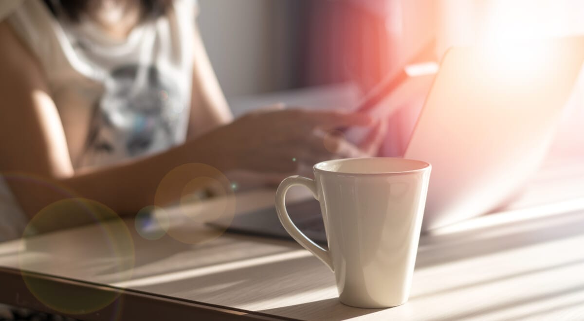 Businesswoman casual holding smartphone and using computer notbo | コーヒーステーション