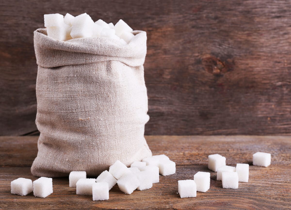 Refined sugar in bag on wooden background | コーヒーステーション