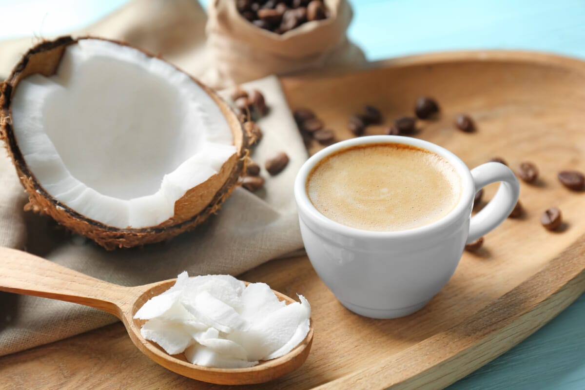 Tray with cup of tasty coconut coffee and nut on table | コーヒーステーション