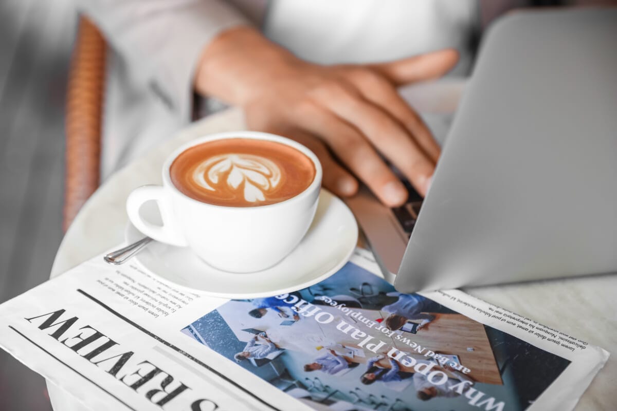 Cup of coffee and newspaper on table in street cafe closeup | コーヒーステーション