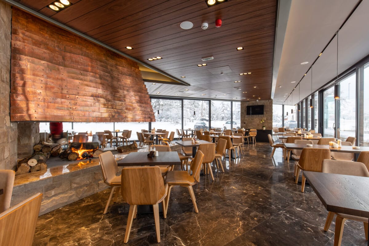 Interior of an empty mountain restaurant with large fireplace in | コーヒーステーション