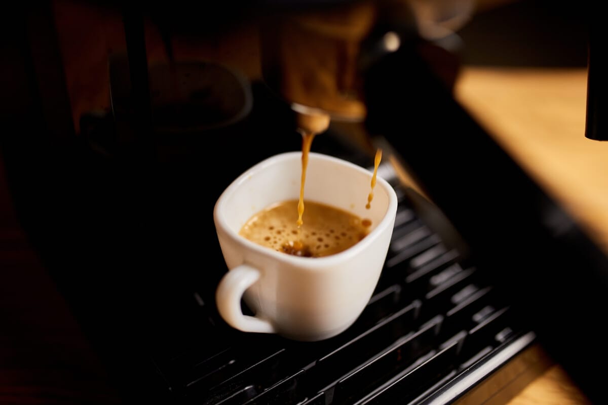 Detail of a professional coffe maker dripping coffe into an empty cup in a cafeteria | コーヒーステーション