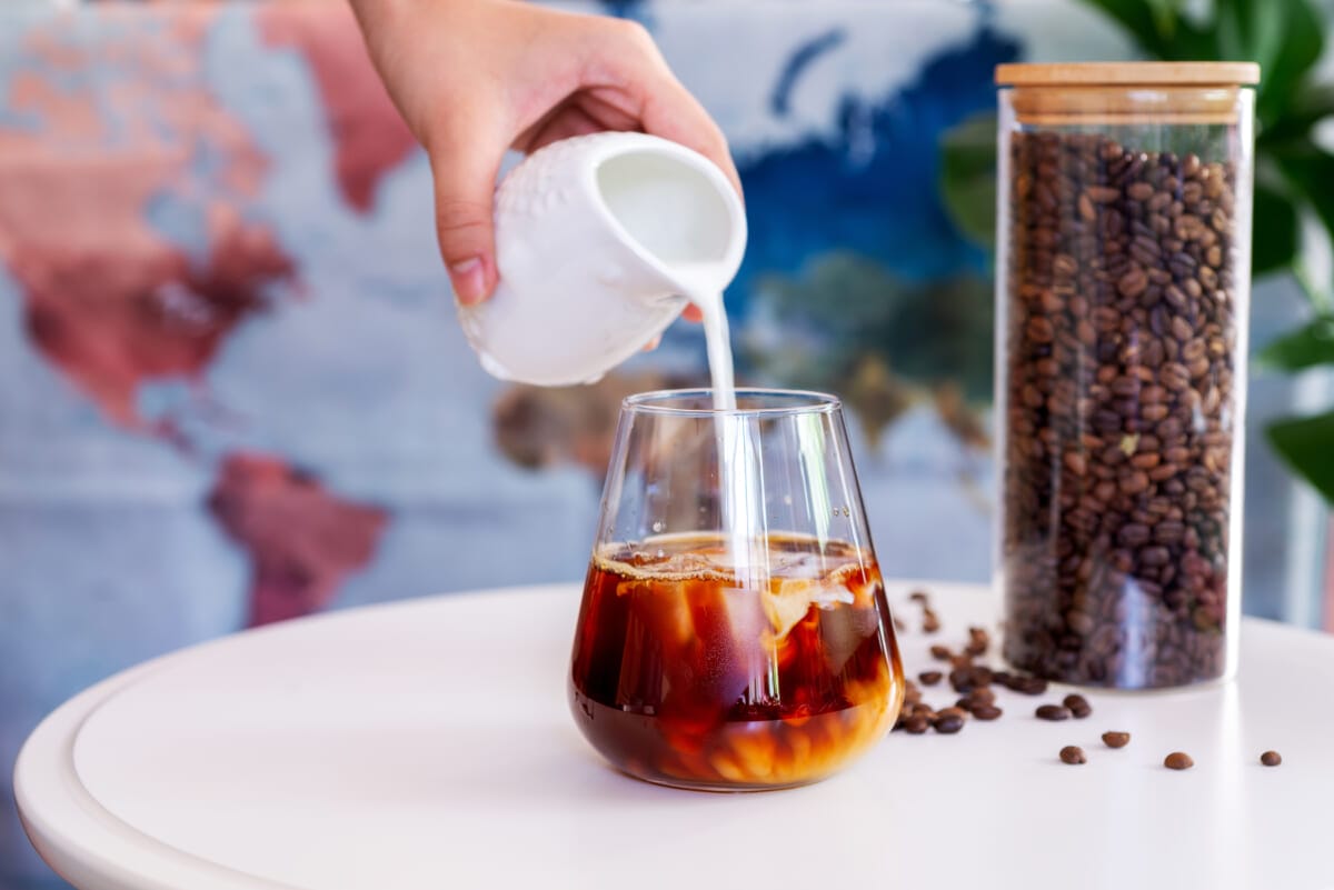 a glass of cold brew coffee with milk on white table | コーヒーステーション