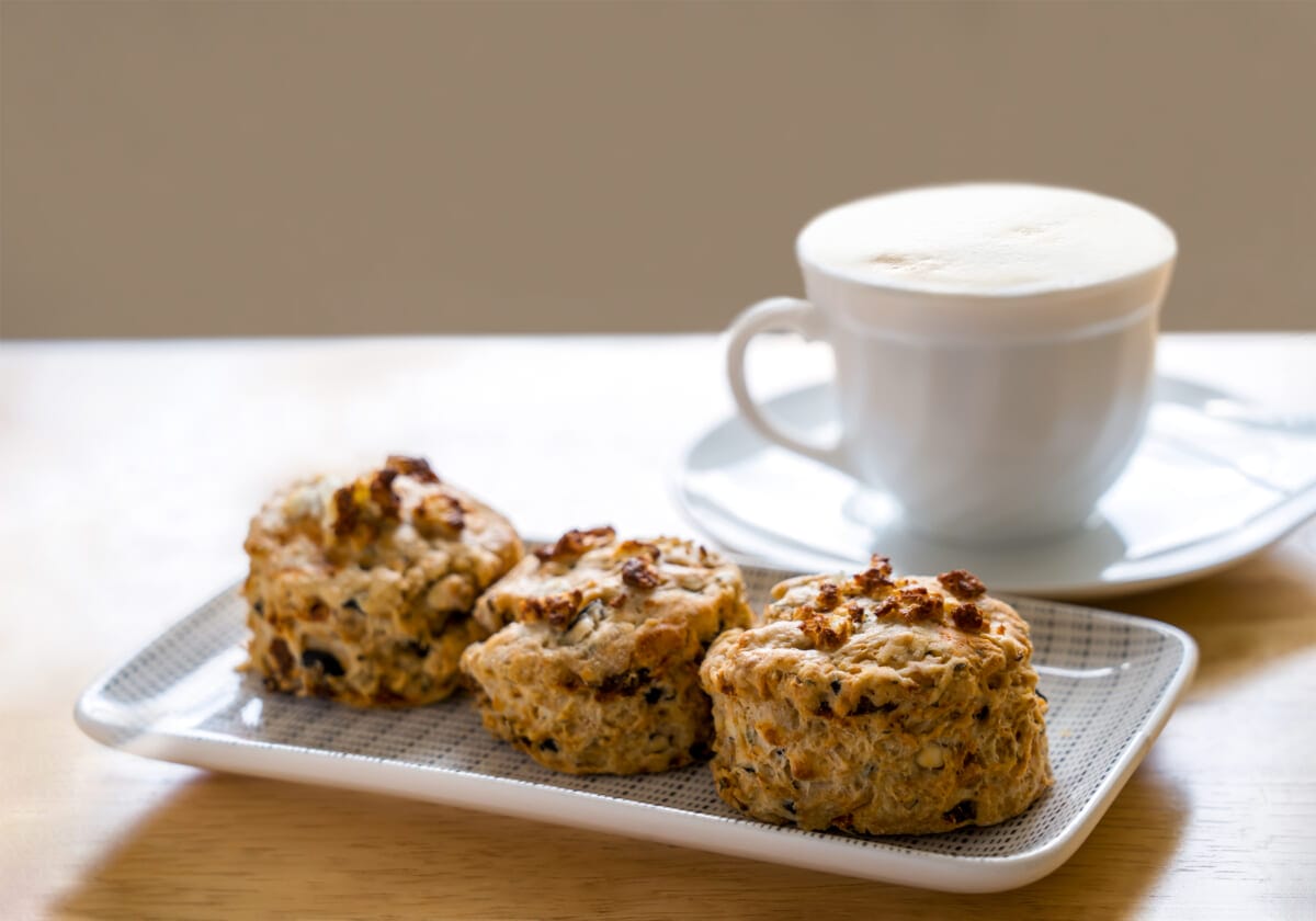 Traditional British cheese scones with blurry cup of coffee and | コーヒーステーション