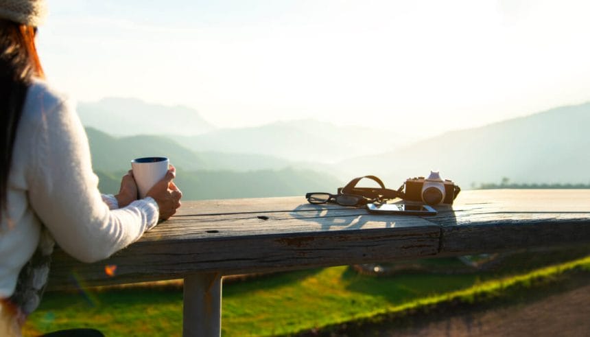 Woman drinking coffee in sun sitting outdoor in sunshine light e | コーヒーステーション