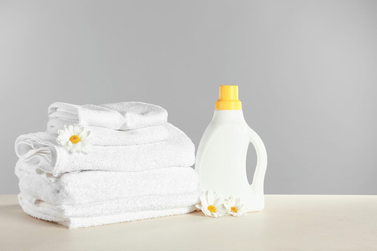 Stack of towels and laundry detergent on table | コーヒーステーション