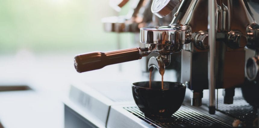 Closeup view of espresso pouring from espresso coffee machine into a coffee cup | コーヒーステーション
