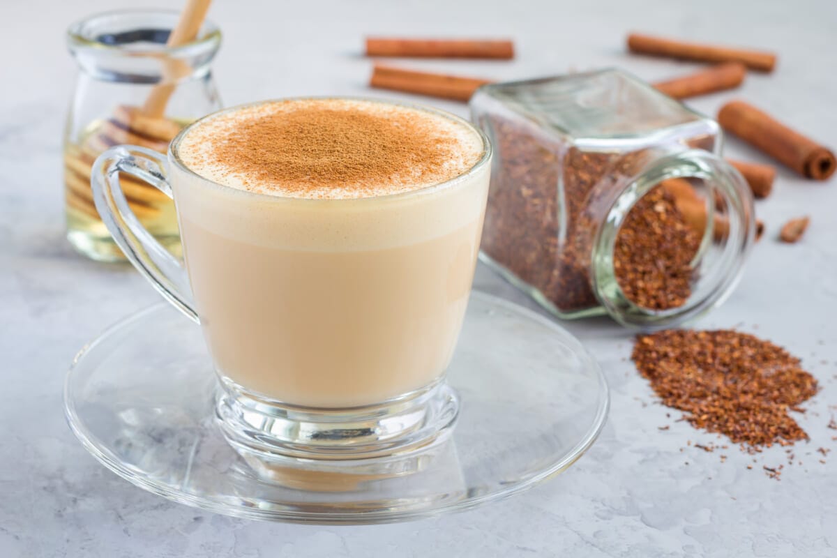 Healthy rooibos red tea latte topped with cinnamon in glass cup and ingredients on background horizontal | コーヒーステーション