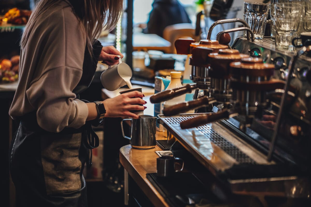 Barista making cappuccion coffee in coffee shop | コーヒーステーション