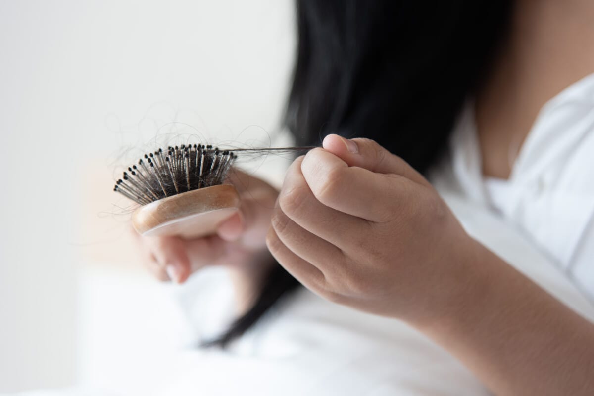 woman looking at her hair for hair loss problem | コーヒーステーション