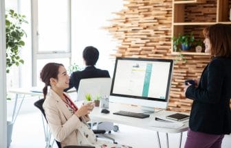 同僚との会話を楽しむ妊婦の女性社員 | コーヒーステーション