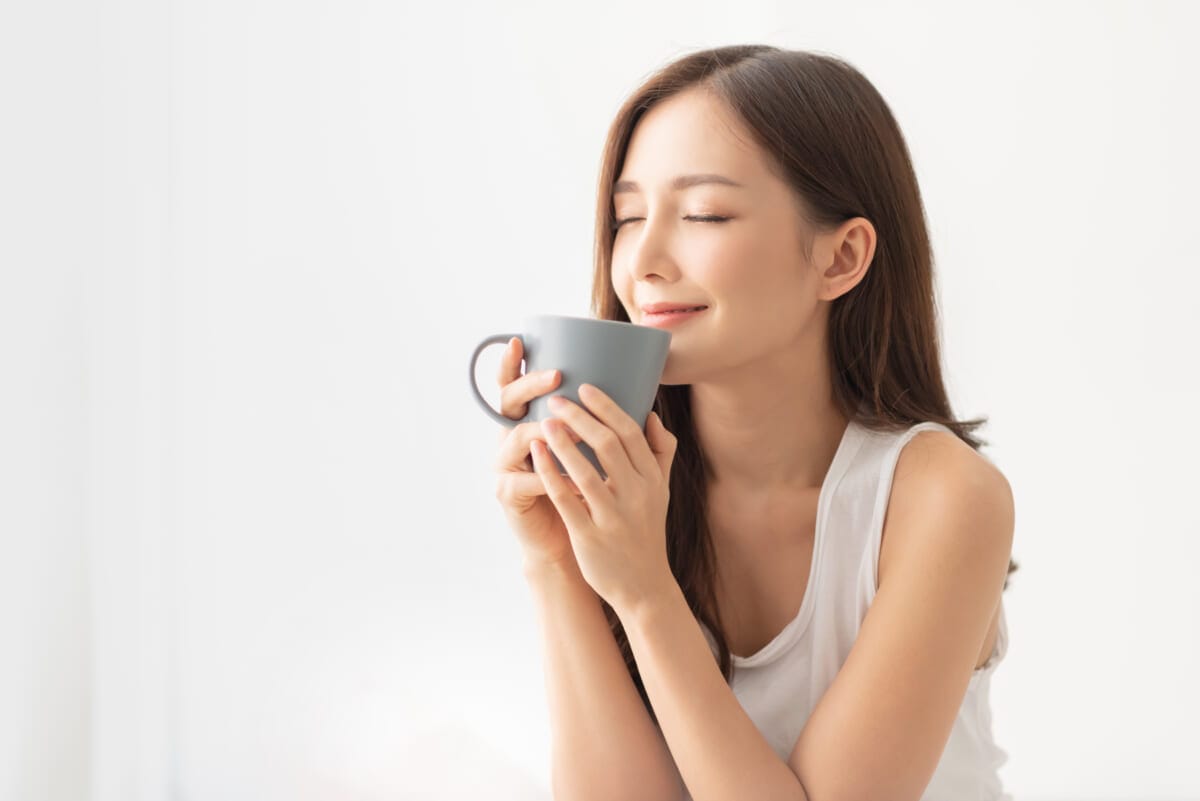 Attractive girl is holding a grey mug | コーヒーステーション