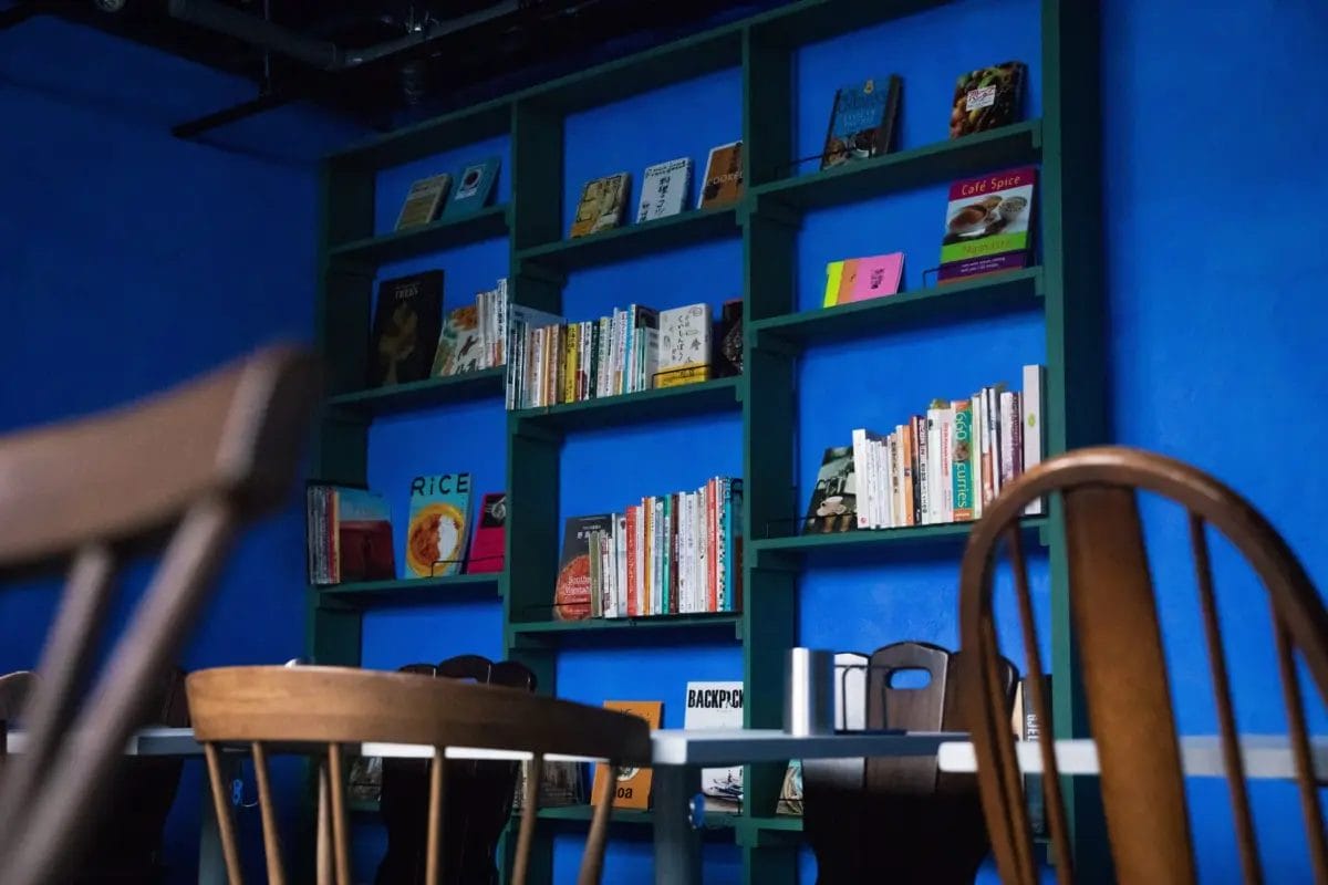 HAVE MORE CURRYの鮮やかな青い壁と緑色の本棚が特徴的な店内